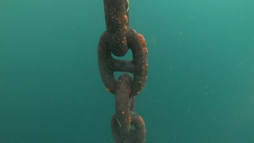 Close-up of rusty metal chain on sea