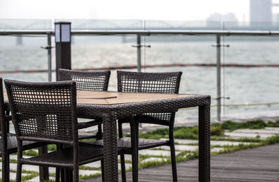 Empty table and chairs by han river