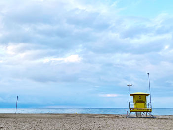 Lifeguard hut on beach against sky