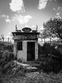 Old abandoned house on field against sky