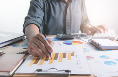 Midsection of businessman working at desk in office