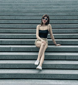 Full length of young woman standing on steps