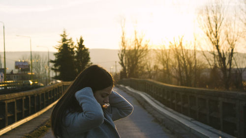 Woman on bridge at sunset