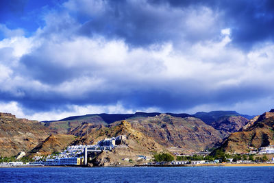 Scenic view of sea by buildings against sky