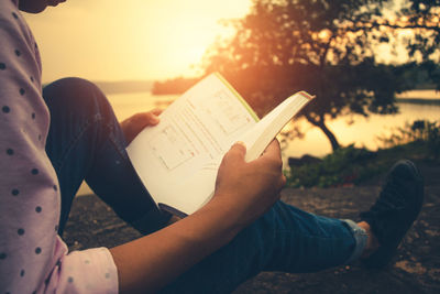 Midsection of woman reading book