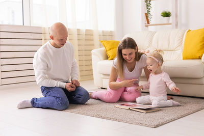 Family sitting on sofa at home