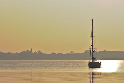 Boats in sea at sunset
