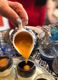 Close-up of hand pouring tea cup