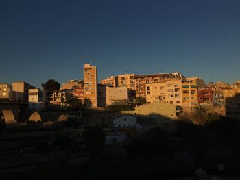 Buildings in town against clear blue sky