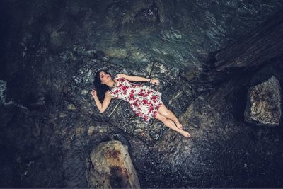 High angle view of woman relaxing on rock