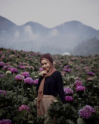 Woman standing on purple flowering plants