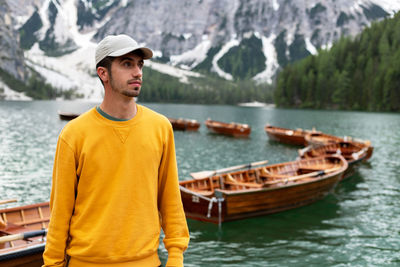 Young man looking away while standing on mountain