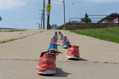 Low section of multi colored shoes on road