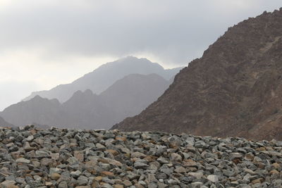 Stones on shore against sky