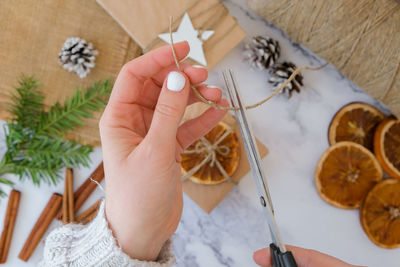 Cropped hand of woman holding christmas decoration