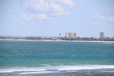 Scenic view of sea by city against sky