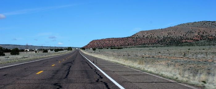 Road by mountain against clear sky