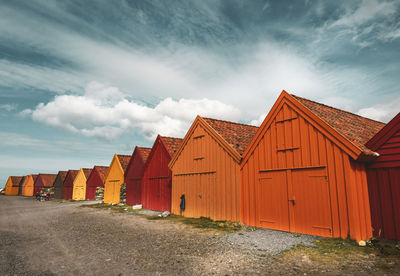 Beach huts by buildings against sky