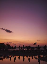 Silhouette people at beach against clear sky during sunset