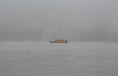 Boat sailing in sea against sky