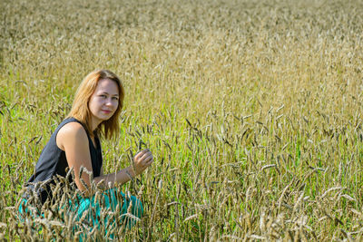 Young woman using smart phone in field