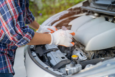 Midsection of man repairing car