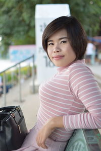 Portrait of smiling woman sitting outdoors