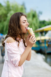 Side view of young woman drinking juice