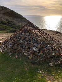 Stack of rocks by sea against sky