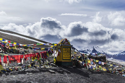 Multi colored flags on snowcapped mountain against sky