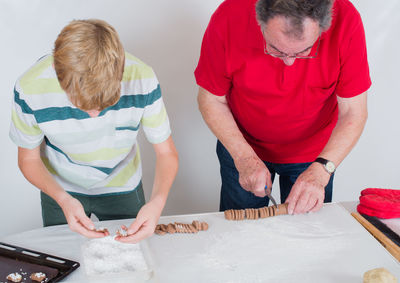 People making cookies on table at home