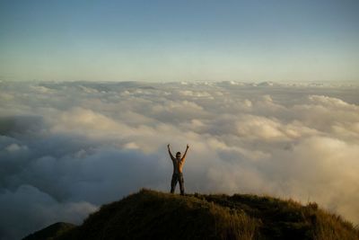 Silhouette man on mountain against sky