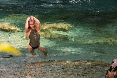 Woman standing on rock by sea