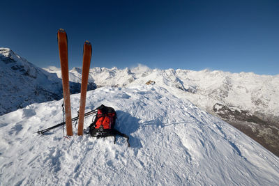 View of people on snowcapped mountain against clear sky