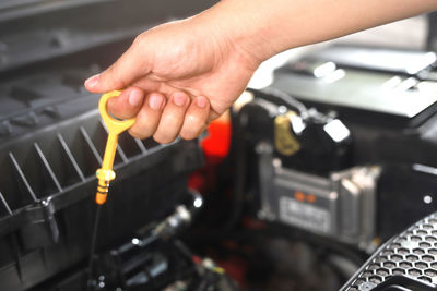 Car mechanic checking engine oil before leaving