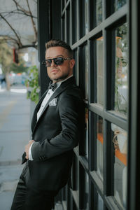 Portrait of young man wearing sunglasses standing outdoors