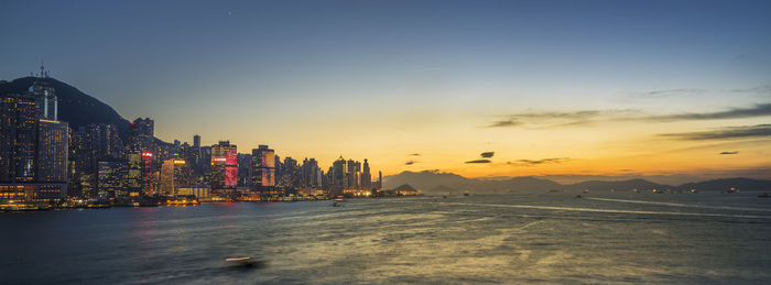 Illuminated buildings in city during sunset