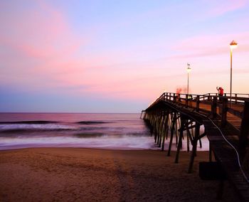 Pier on sea at sunset