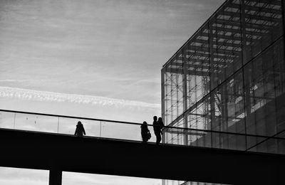 People walking on bridge against sky