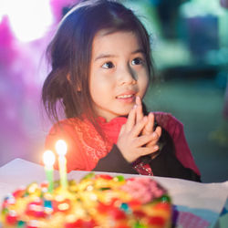 Close-up of happy girl with birthday cake on table