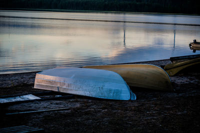 Upside down boats at beach during sunset