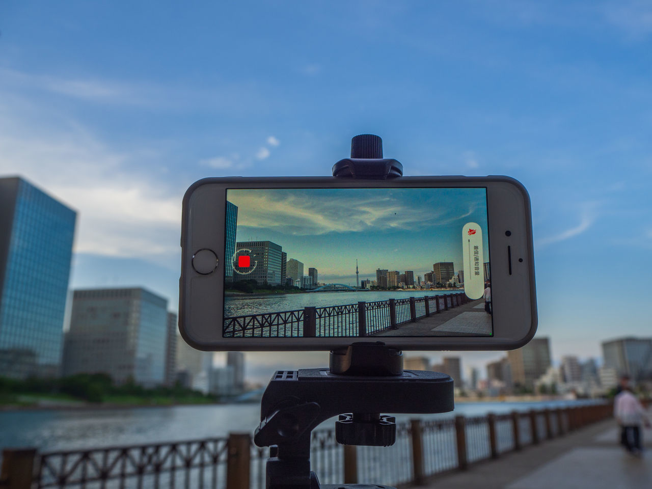 CLOSE-UP OF CAMERA AGAINST BUILDINGS