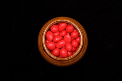 Close-up of strawberries in bowl against black background