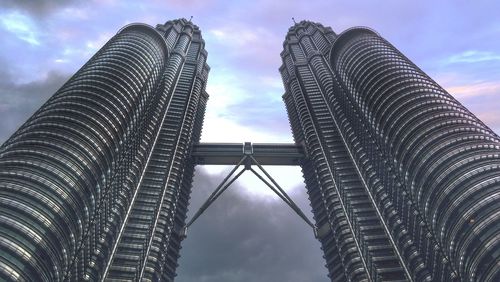 Low angle view of modern building against cloudy sky