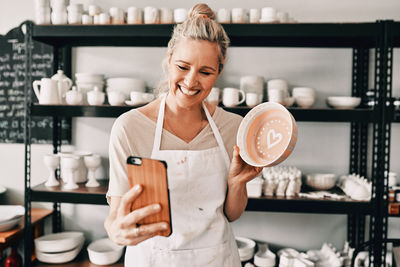 Portrait of smiling young woman using mobile phone