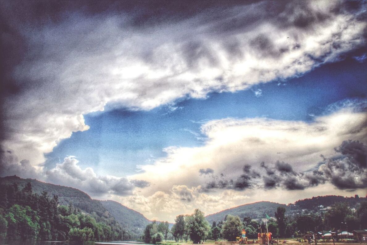 sky, mountain, cloud - sky, tree, mountain range, cloudy, scenics, cloud, building exterior, built structure, beauty in nature, architecture, tranquil scene, nature, landscape, tranquility, town, outdoors, weather, day