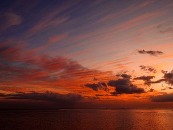 Scenic view of sea against dramatic sky during sunset