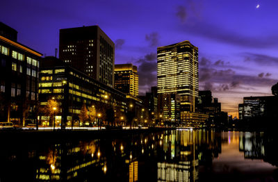 Illuminated buildings in city against sky at night