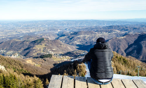 Man looking at mountains against sky