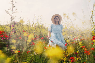 Full length of smiling young woman on field